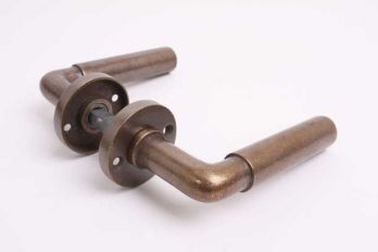 Deurkruk Bauhaus rond brons antiek met rozetten per paar