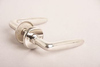 Deurkruk Dudok blinkend nikkel met ronde rozetten per paar. Paar klassieke deurkrukken gemaakt van massief messing in de afwerking blinkend nikkel. 